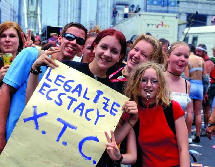Love Parade Berlin 1995 — group of young people holding a handmade sign reading LEGALIZE ECSTASY X.T.C.